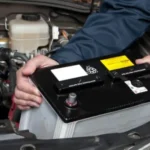 homem instalando bateria de carro